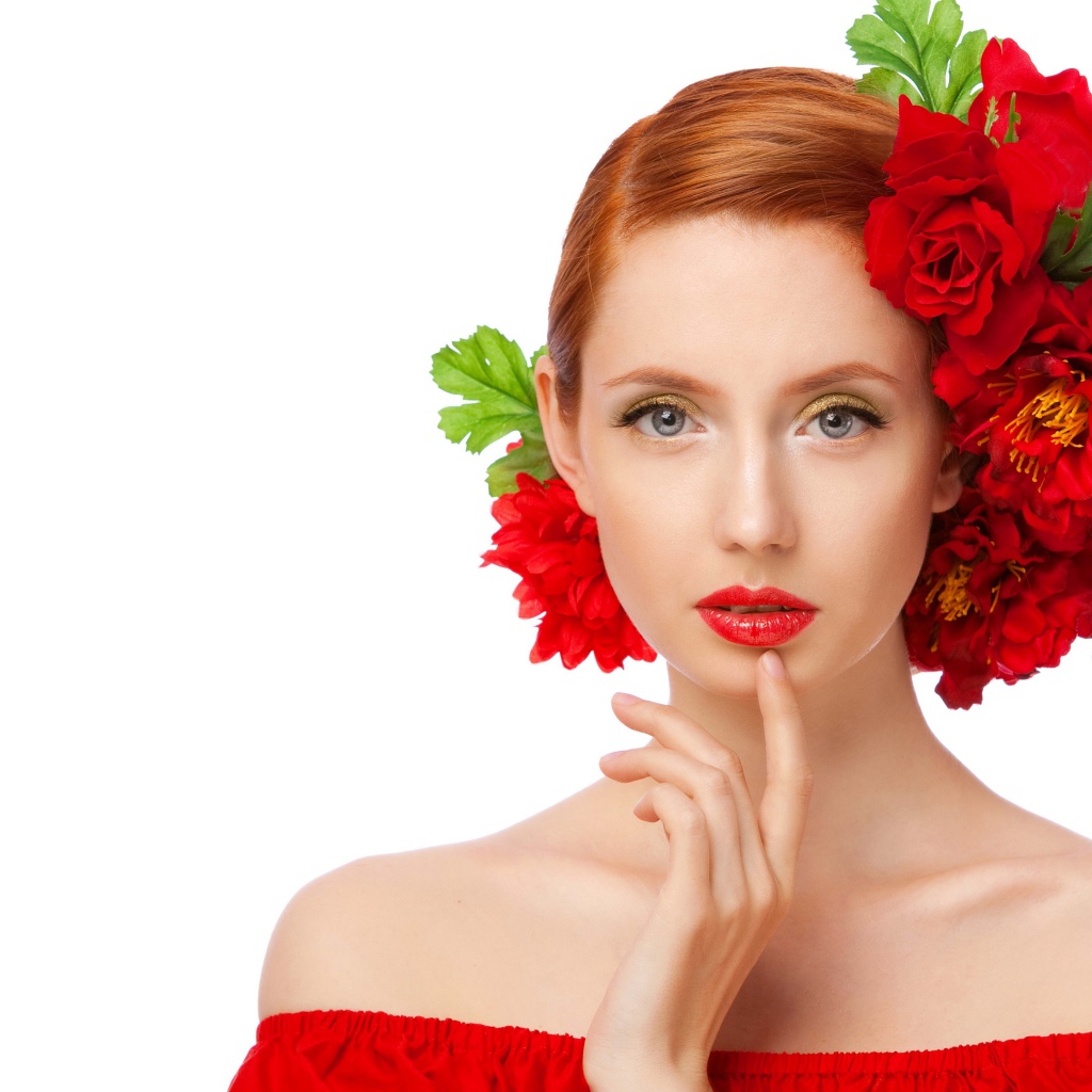 Красивая яркая девушка с красными цветами в волосах на белом фоне