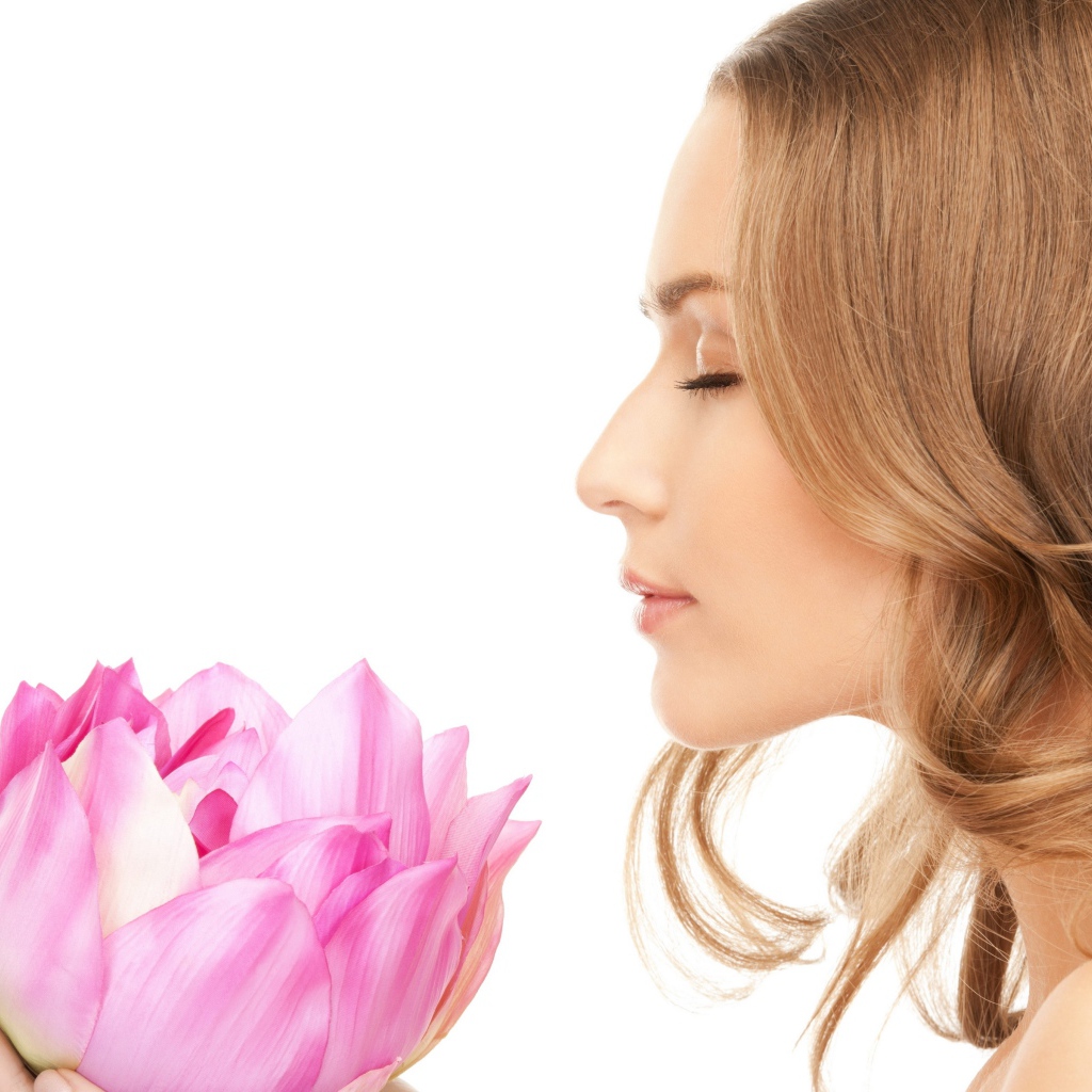 Красивая девушка шатенка наслаждается ароматом лотоса 