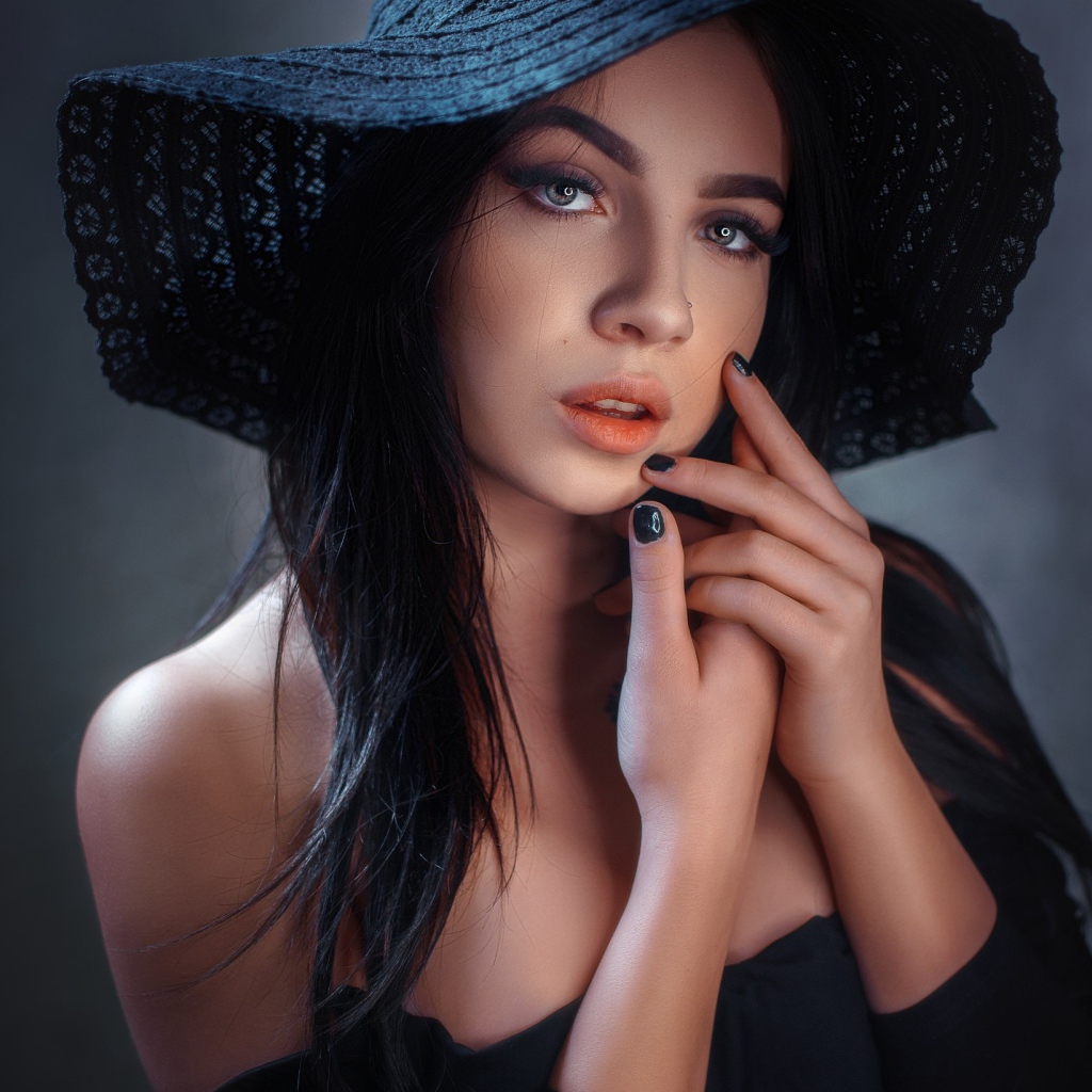 Красивая брюнетка в большой черной шляпе 