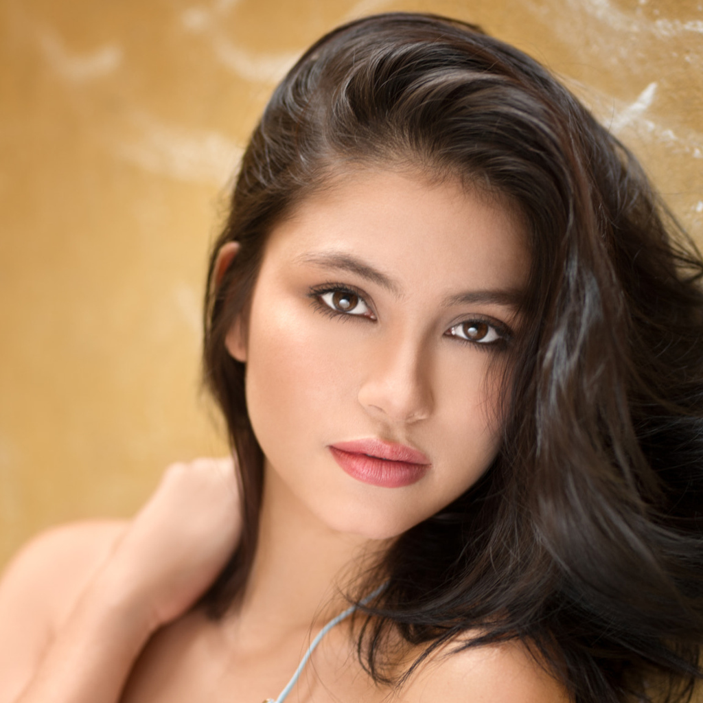 Красивая брюнетка на фоне стены 