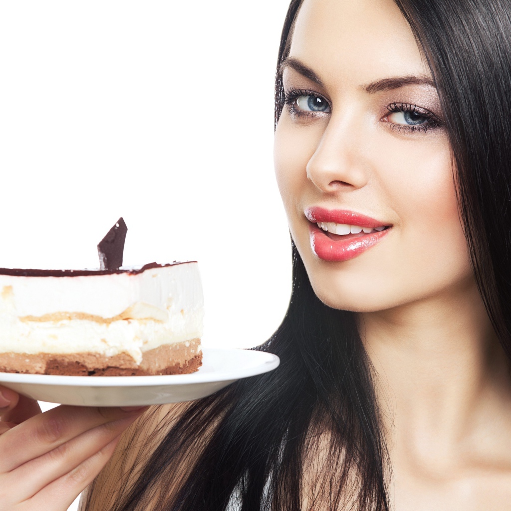 Красивая брюнетка с куском торта на блюдце