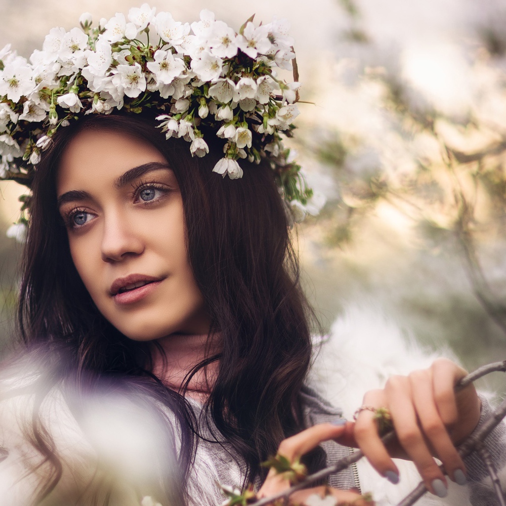Красивая брюнетка с венком из цветов вишни на голове
