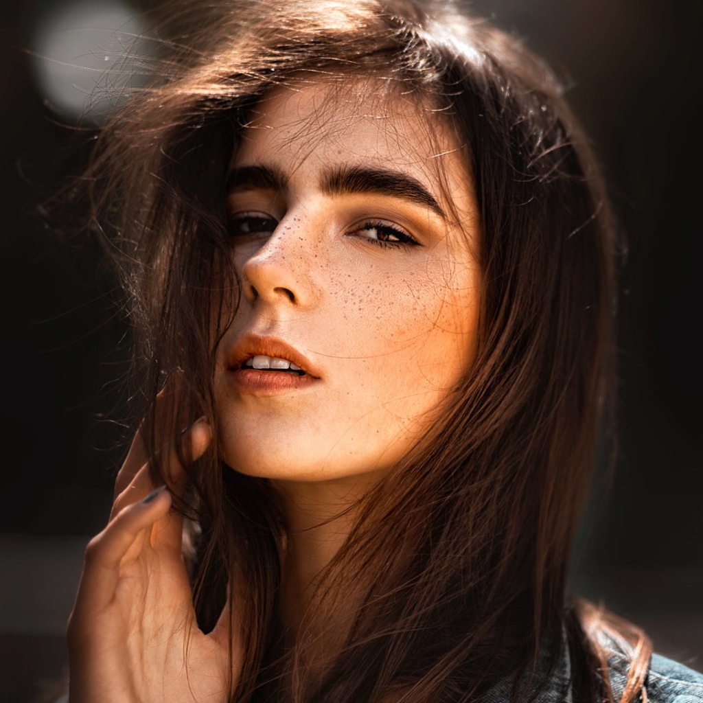 Красивая брюнетка с веснушками на лице