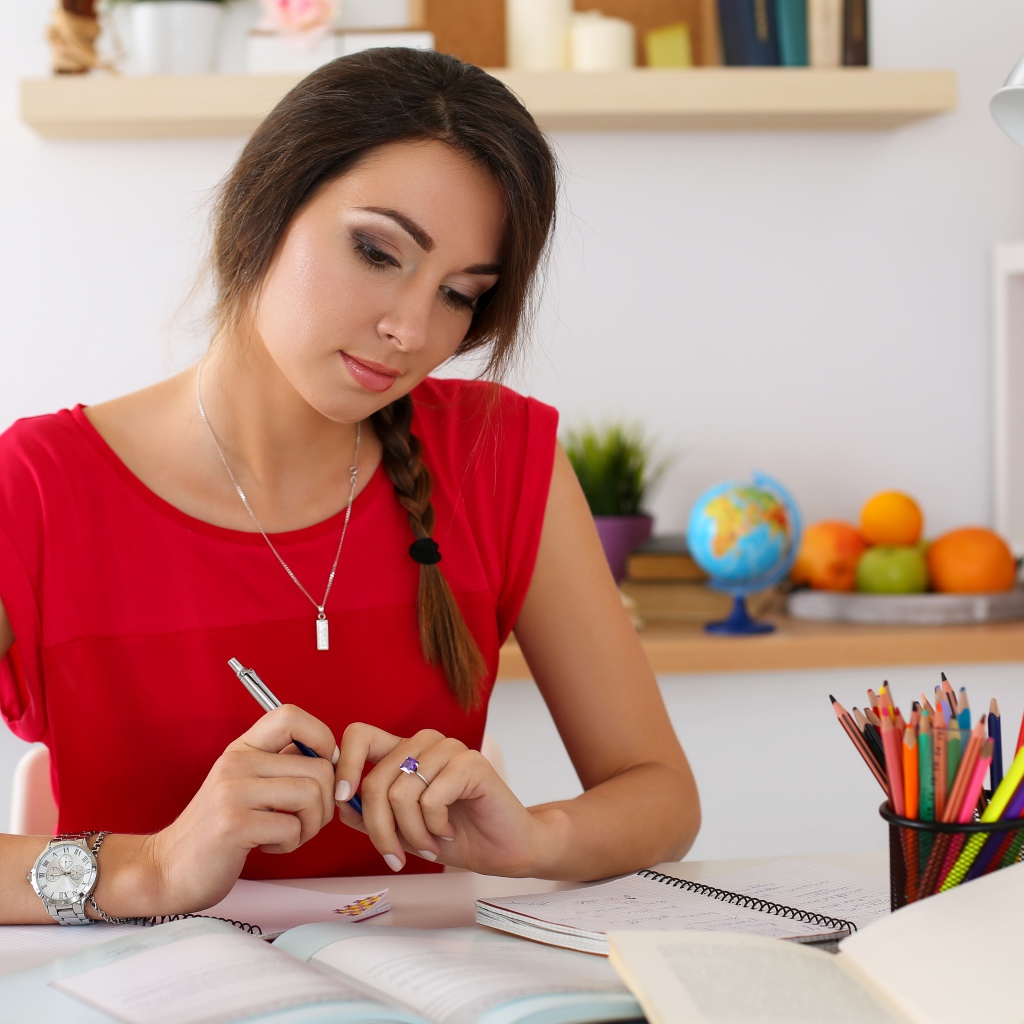 Красивая деловая девушка за столом с тетрадями