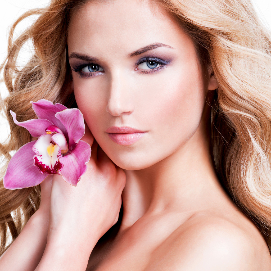 Красивая нежная блондинка с цветком орхидеи на белом фоне