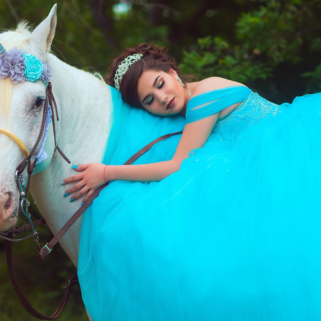 Красивая девушка в пышном голубом платье на лошади