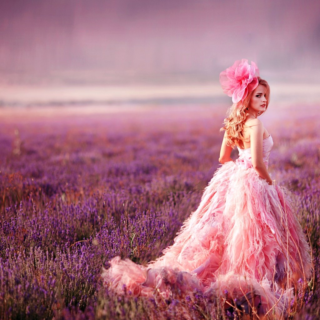 Красивая девушка в розовом платье гуляет по лавандовому полю