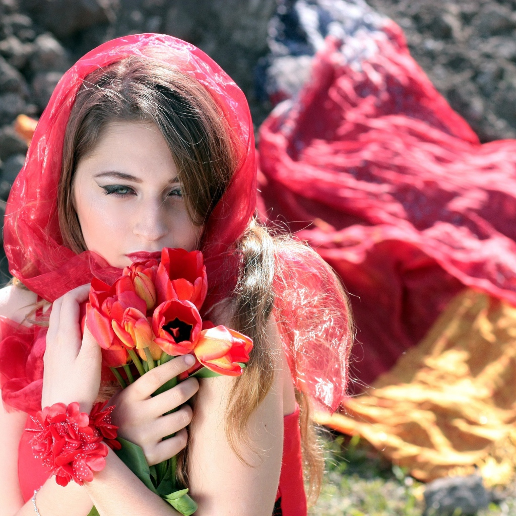 Красивая девушка в красной шали с букетом тюльпанов