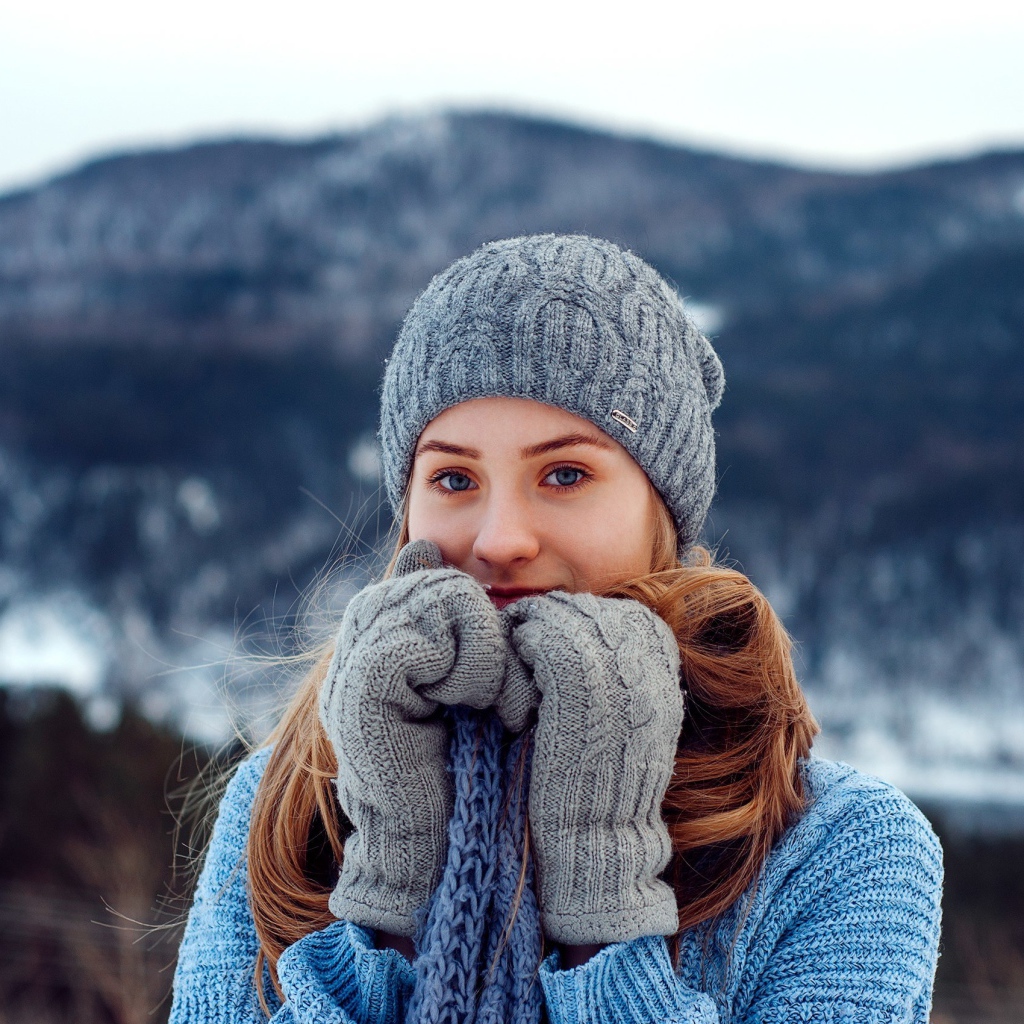 Красивая девушка в теплой шапке и варежках