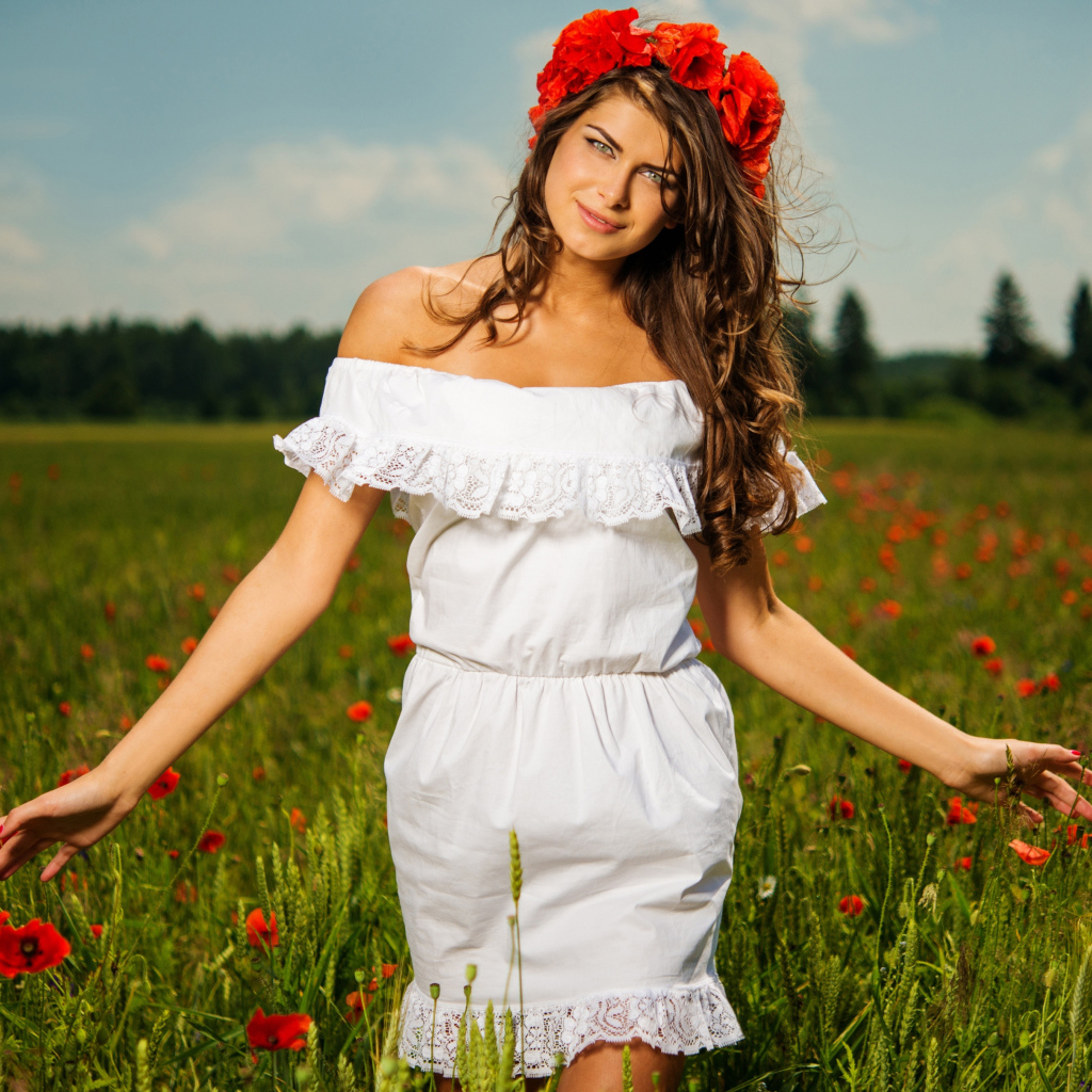 Красивая девушка в белом платье с венком из красных маков на голове 