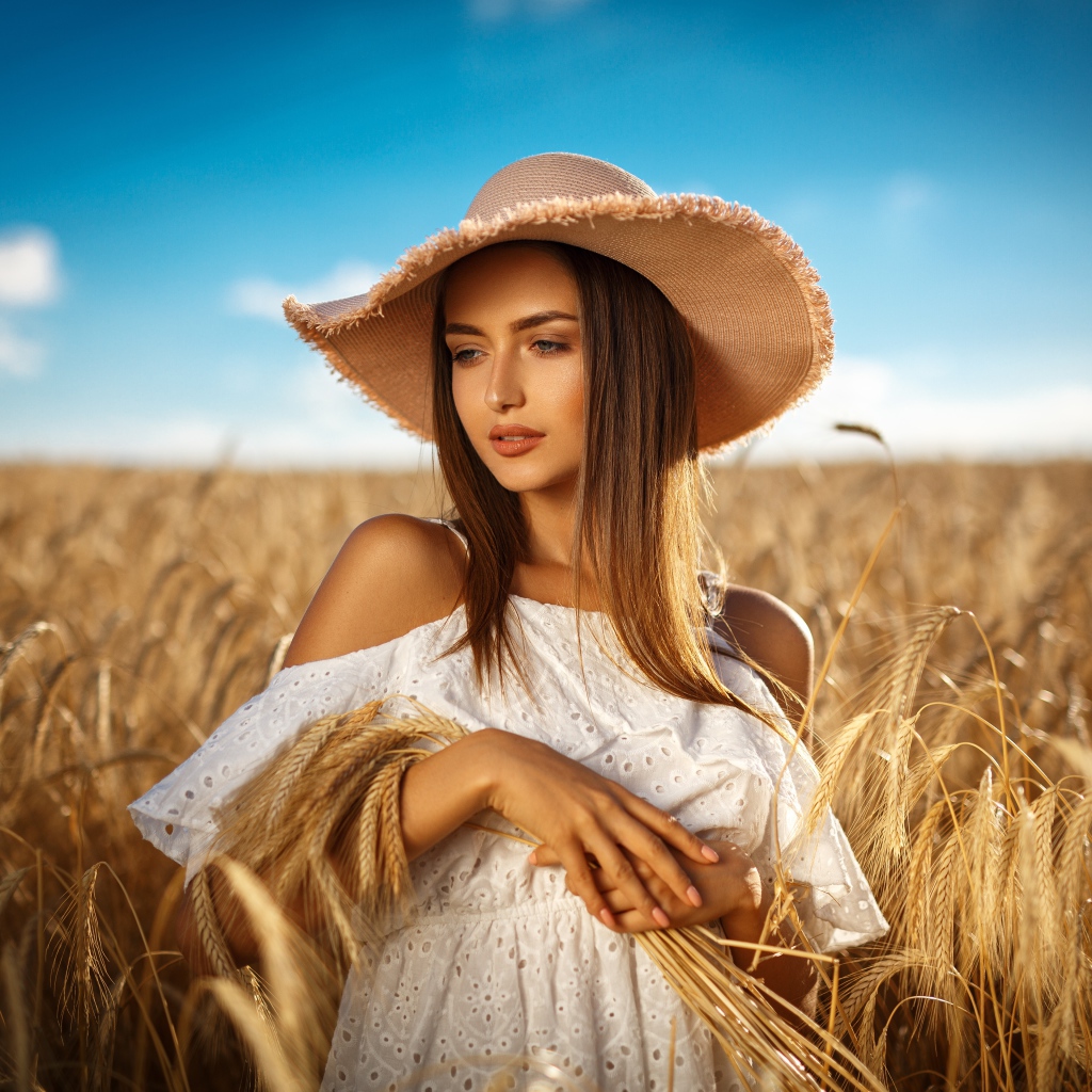 Красивая девушка в белом платье с колосьями пшеницы