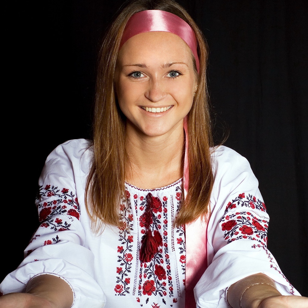 Красивая девушка в вышитой рубашке на черном фоне