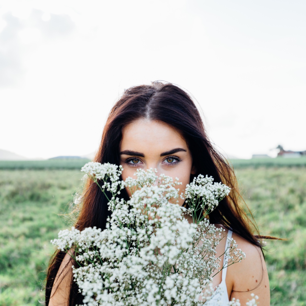 Красивая девушка с букетом полевых цветов
