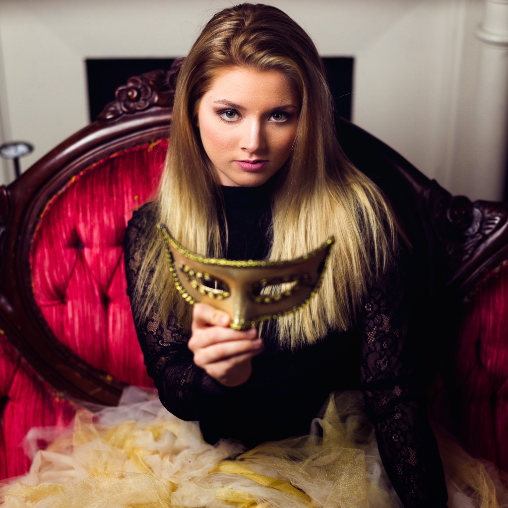 Красивая девушка с маской в руках