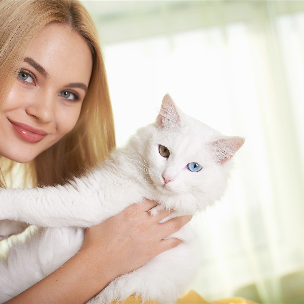 Красивая девушка с белым котом в руках