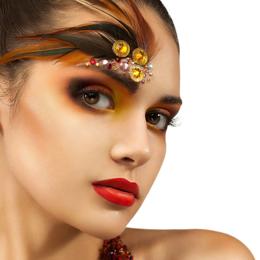 Красивая девушка с ярким макияжем и стразами на лице