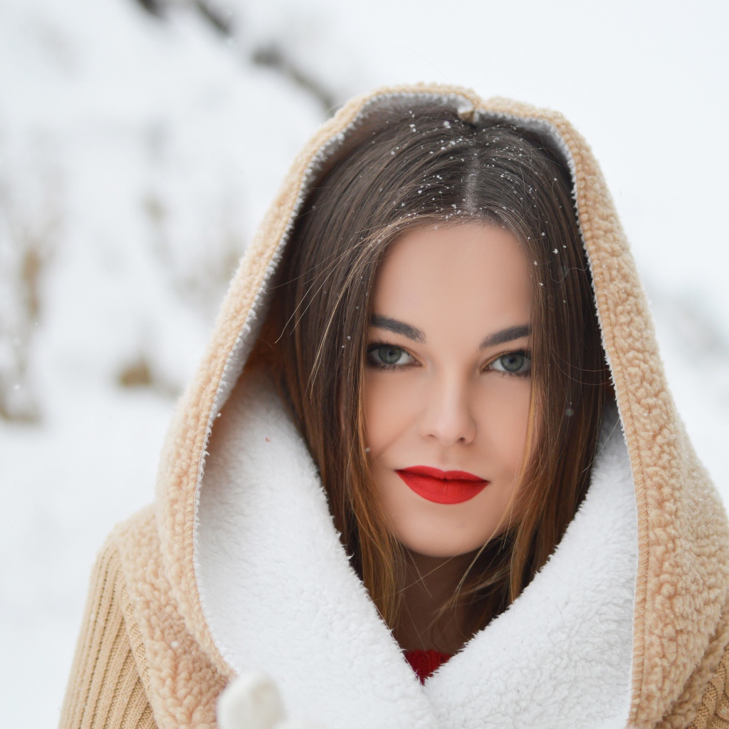 Красивая девушка с красными губами в теплой куртке зимой