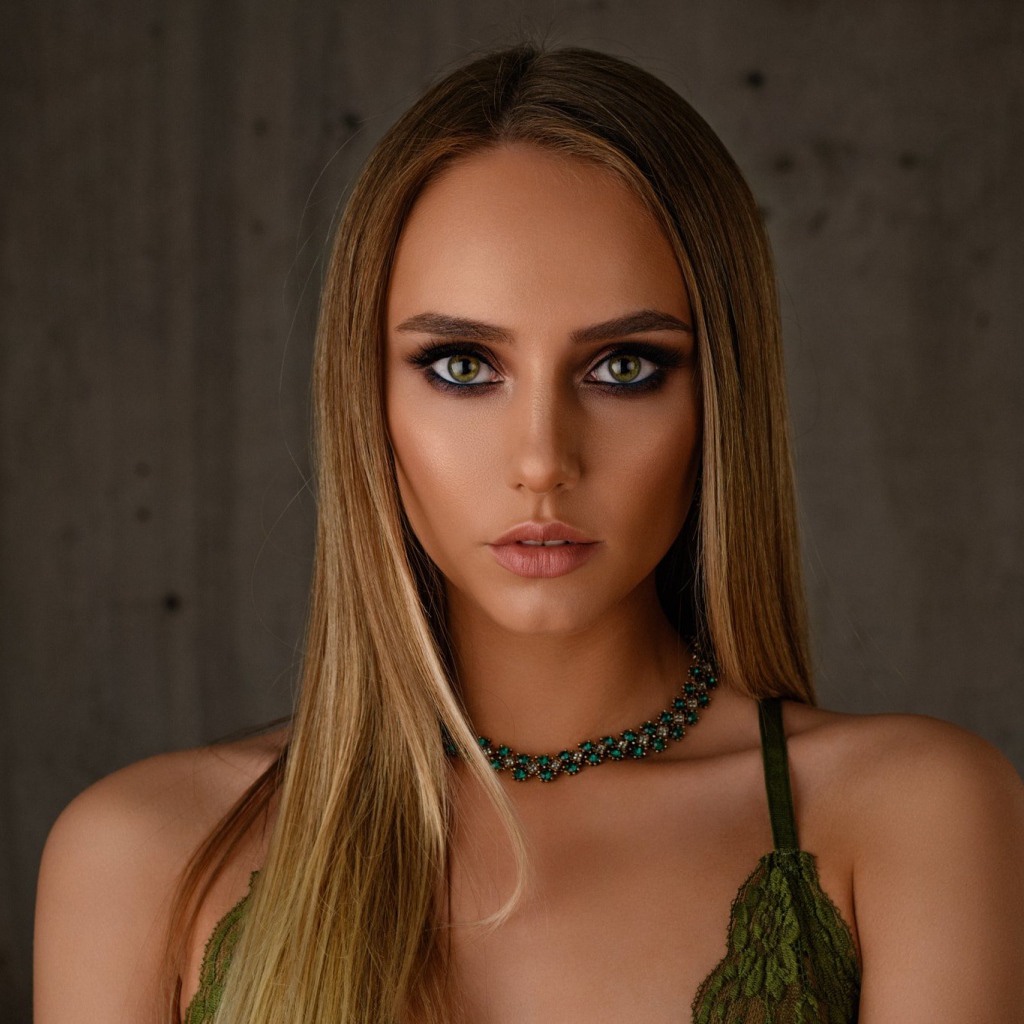 Красивая длинноволосая блондинка с украшением на шее 