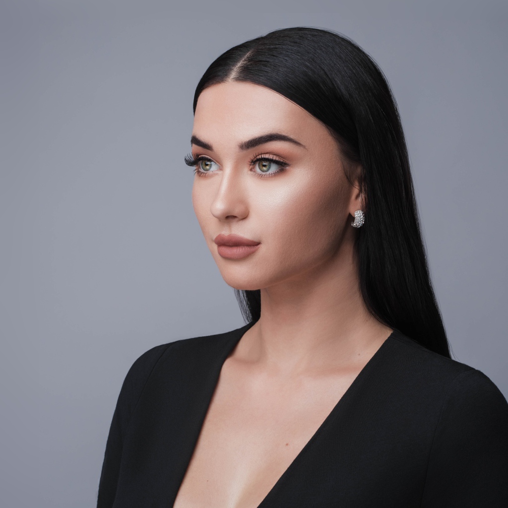 Красивая длинноволосая брюнетка в черном фото на сером фоне