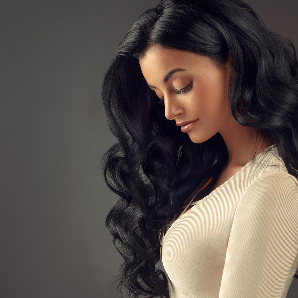 Beautiful long-haired brunette on a gray background