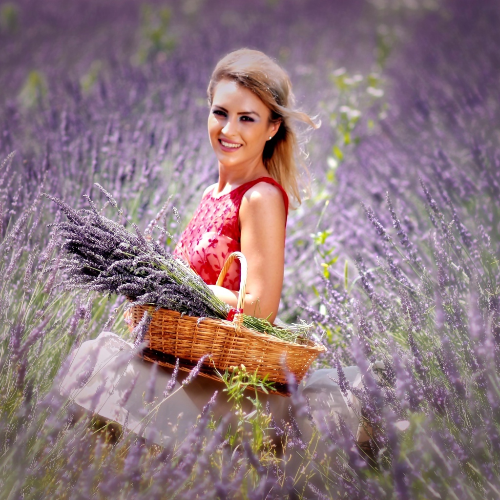 Красивая улыбающаяся девушка с корзиной на лавандовом поле