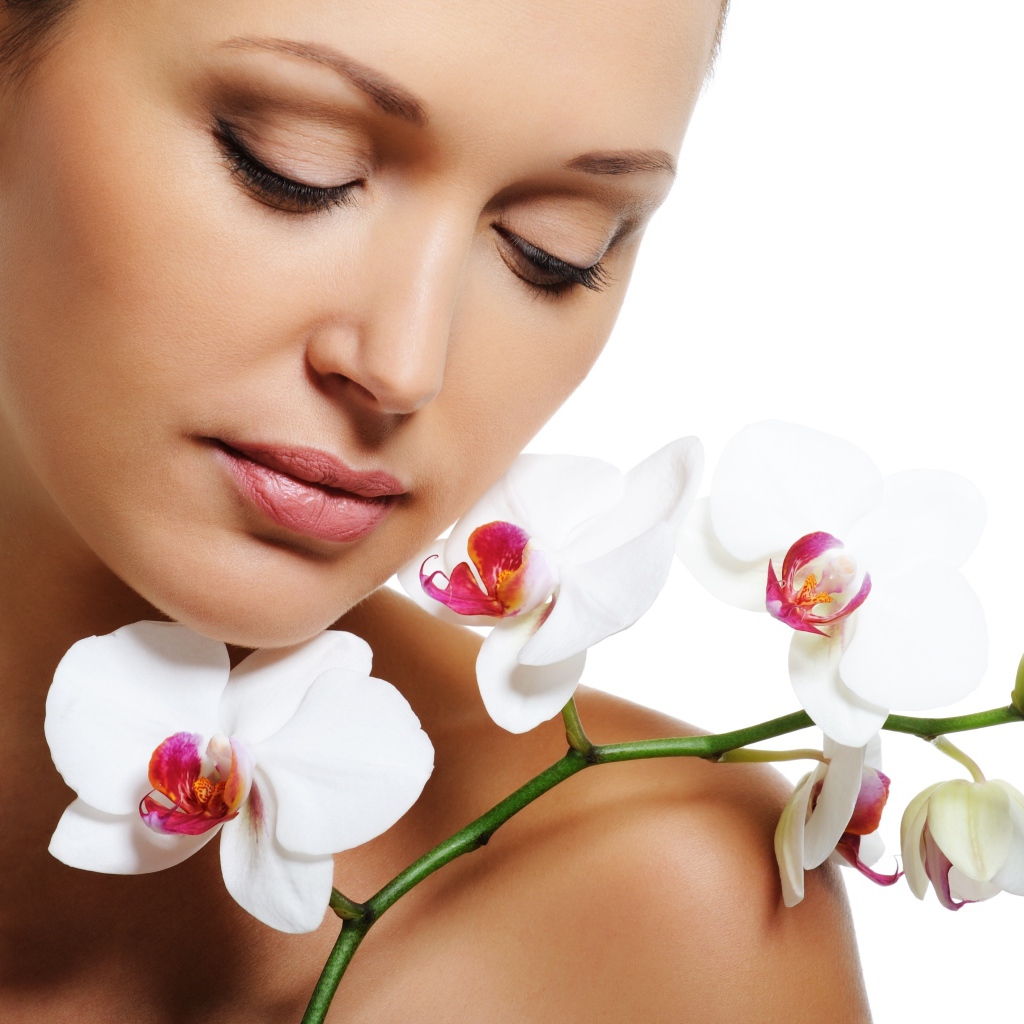 Красивая нежная девушка с цветами орхидеи на белом фоне