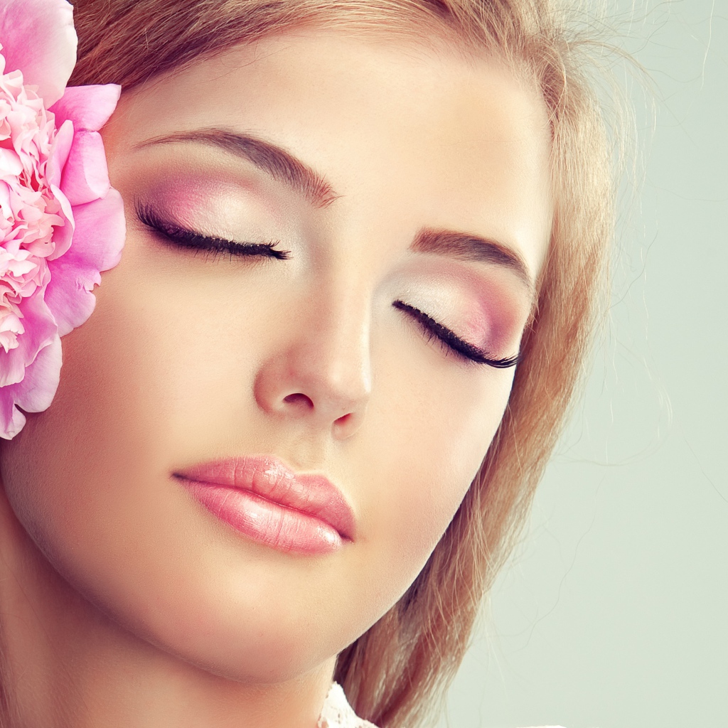 Красивая нежная молодая девушка с розовым цветком пиона в волосах 