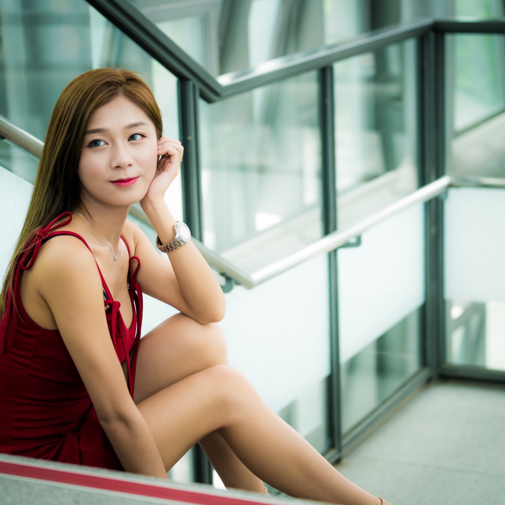 Красивая молодая девушка азиатка сидит на ступенях