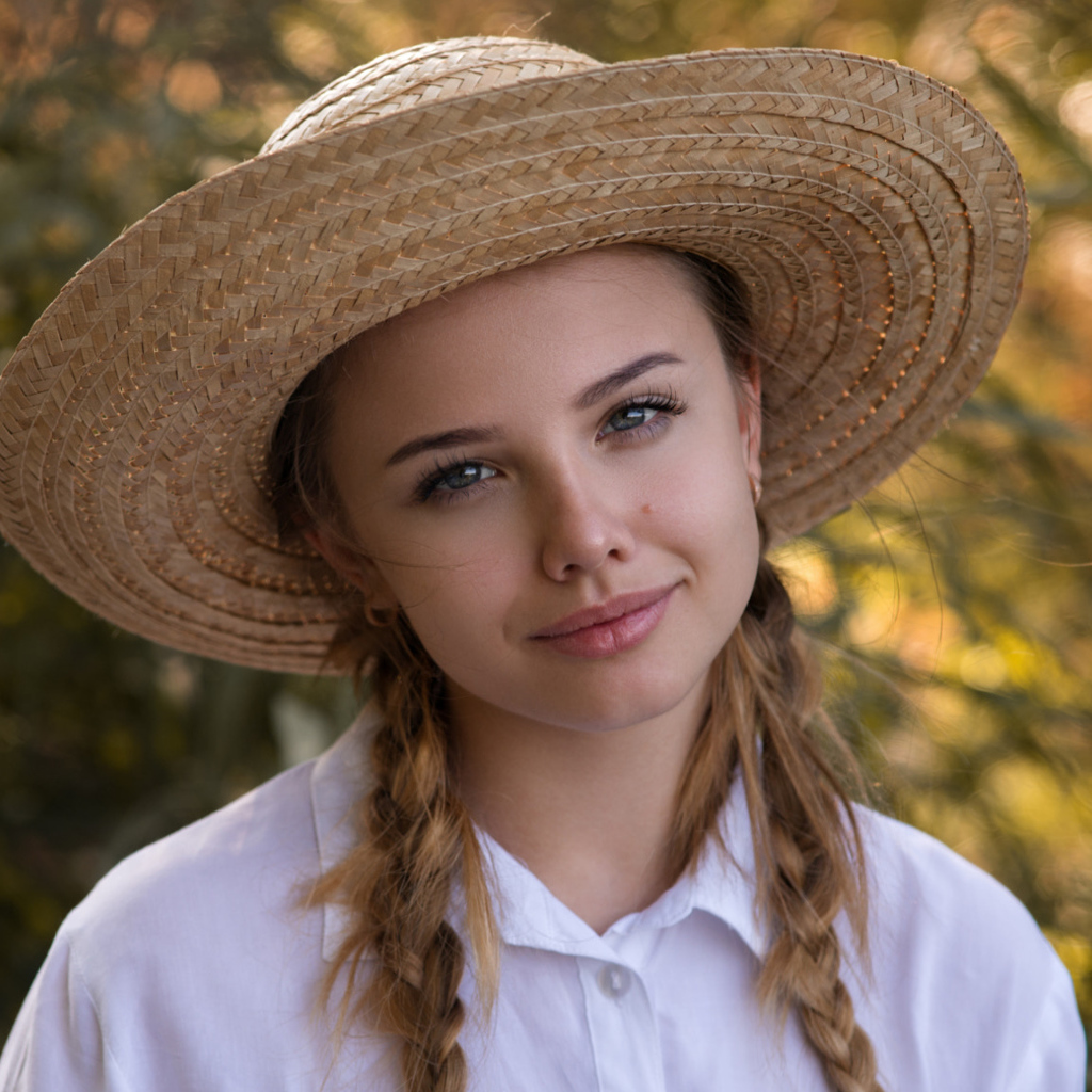 Красивая молодая девушка в соломенной шляпе