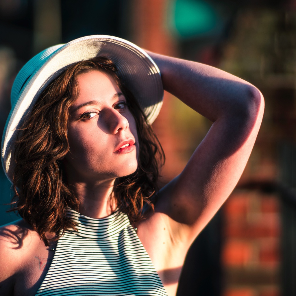 Красивая молодая девушка в белой шляпе в свете солнца