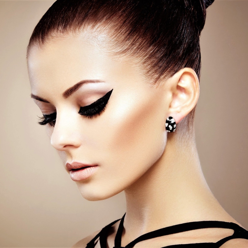 Красивая молодая девушка с макияжем и красивыми серьгами