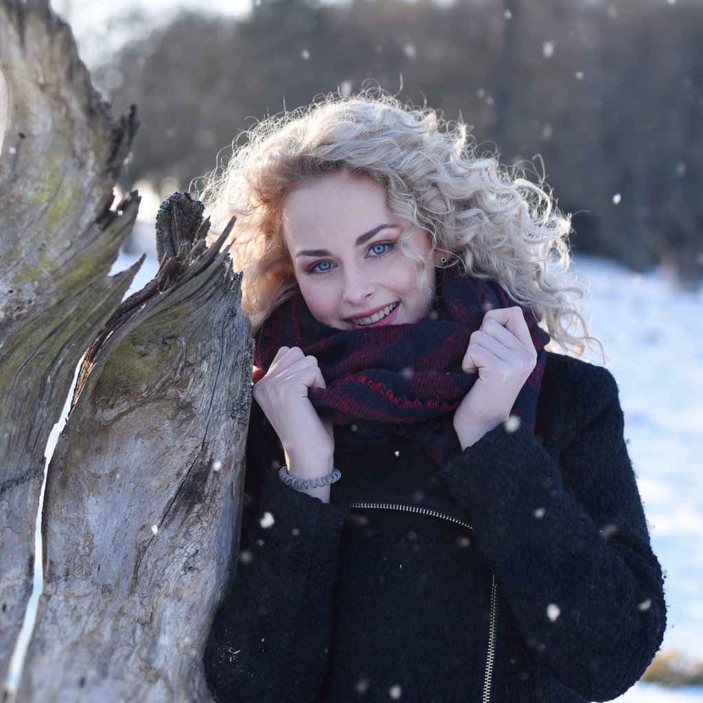 Голубоглазая блондинка у сухого дерева зимой