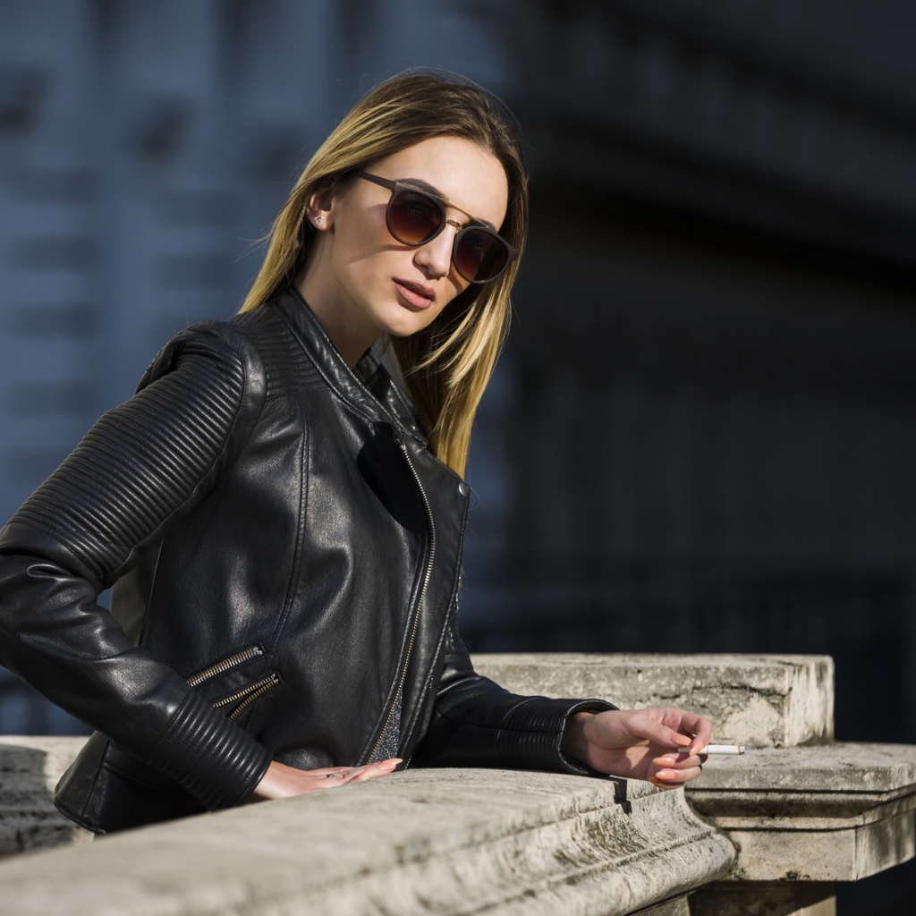 Дерзкая девушка в черной кожаной куртке и очках