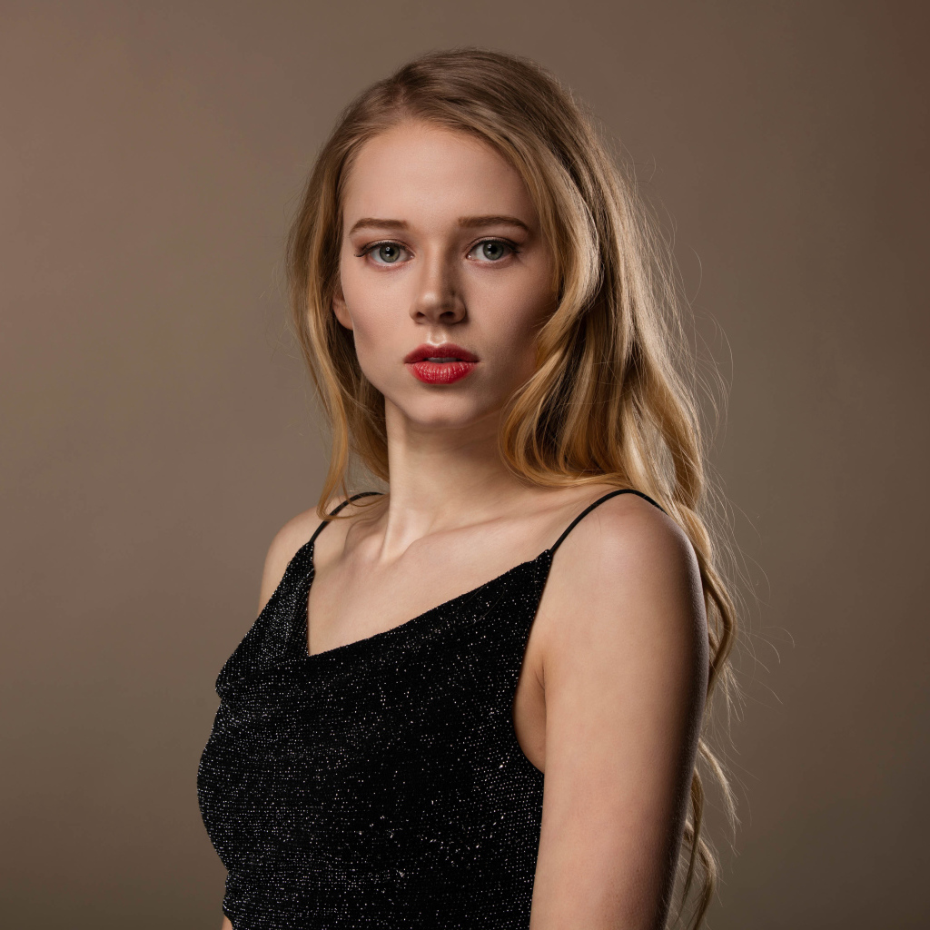 Нежная девушка модель в черном платье на сером фоне