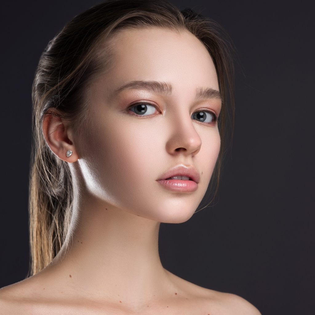 Нежная настоящая девушка шатенка на сером фоне