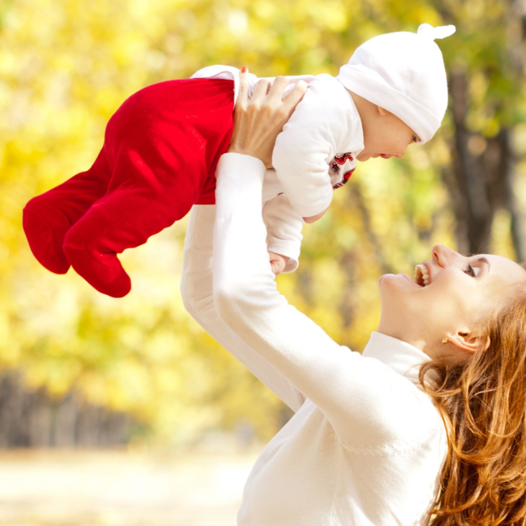 Счастливая девушка с младенцем на руках