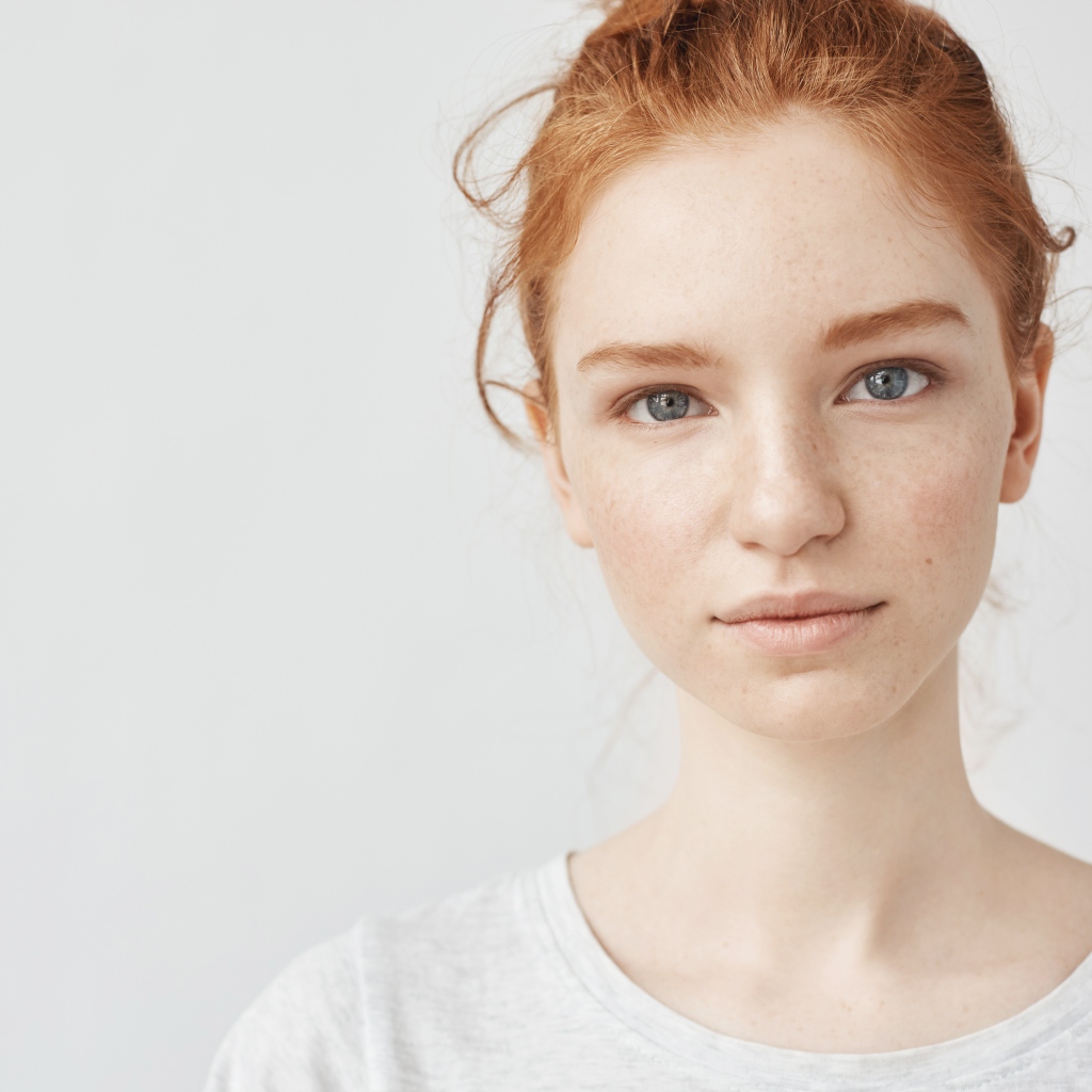 Рыжеволосая девушка на сером фоне