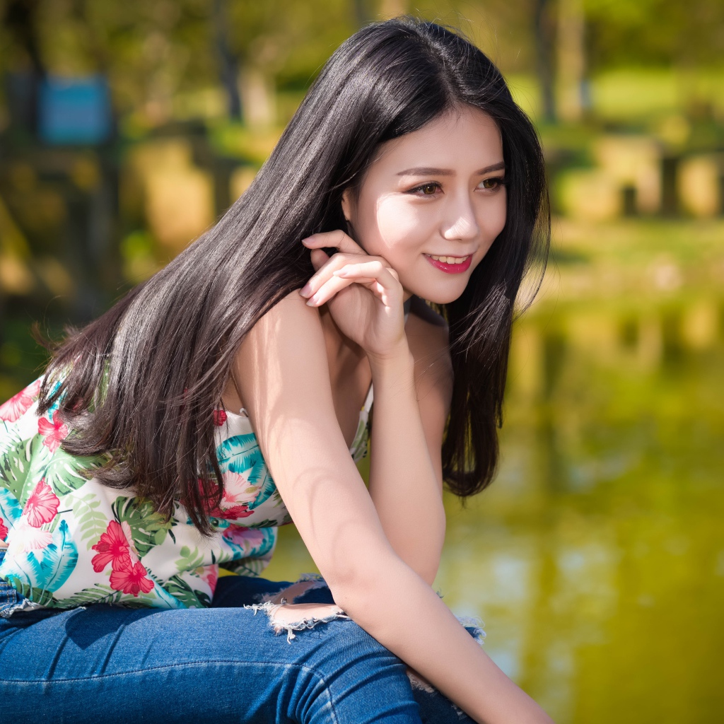 Улыбающаяся красивая девушка азиатка у воды