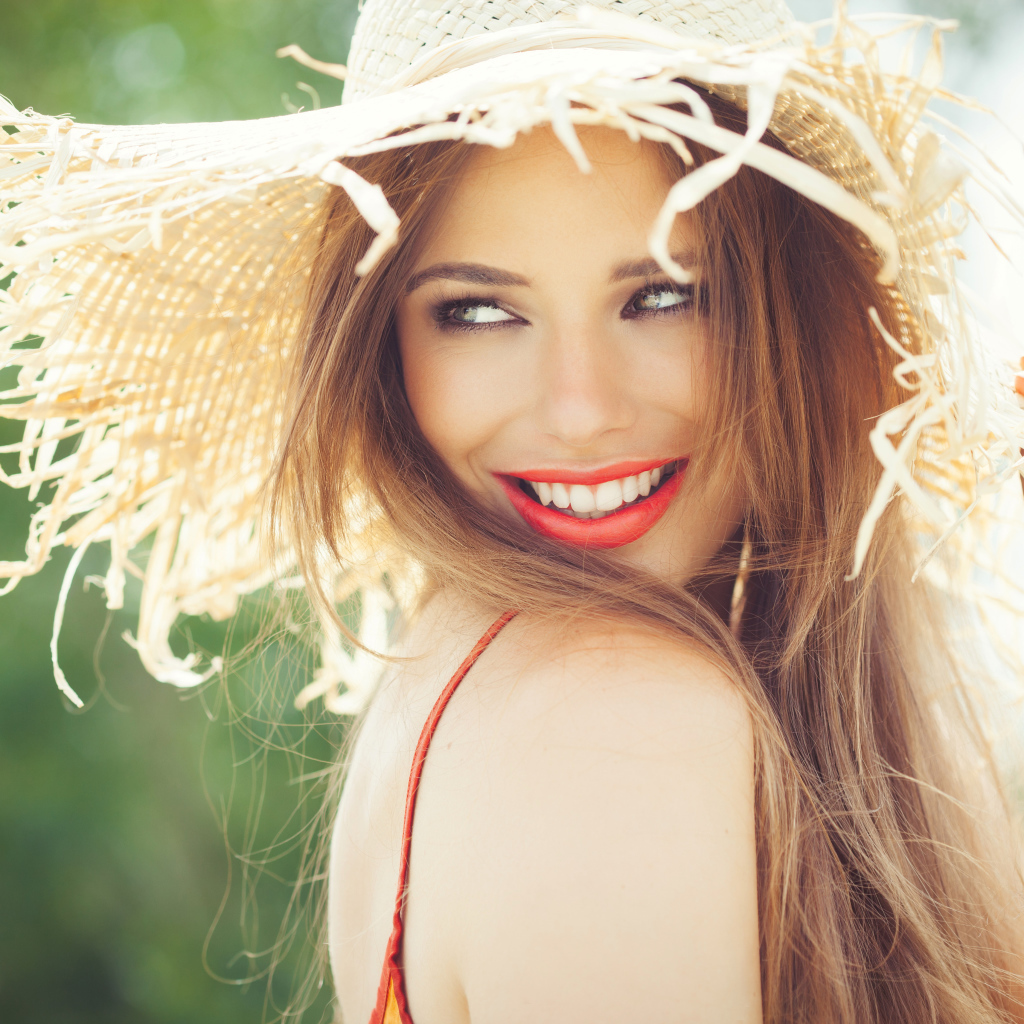 Улыбающаяся девушка в соломенной шляпе летом