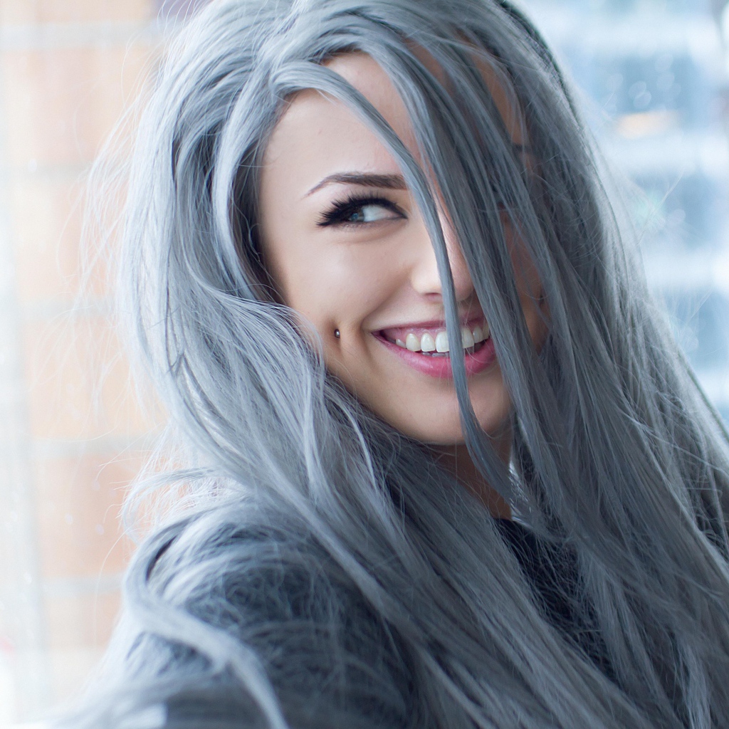 Улыбающаяся эпатажная девушка с пирсингом