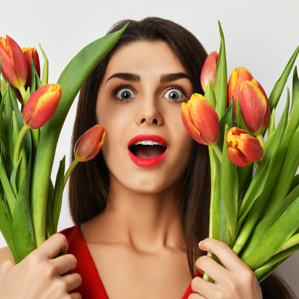 Удивленная шатенка с букетами тюльпанов