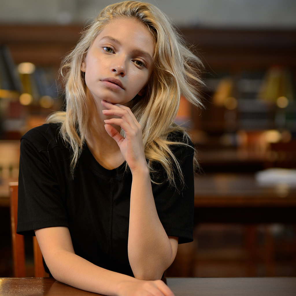 Нежная девушка блондинка в библиотеке