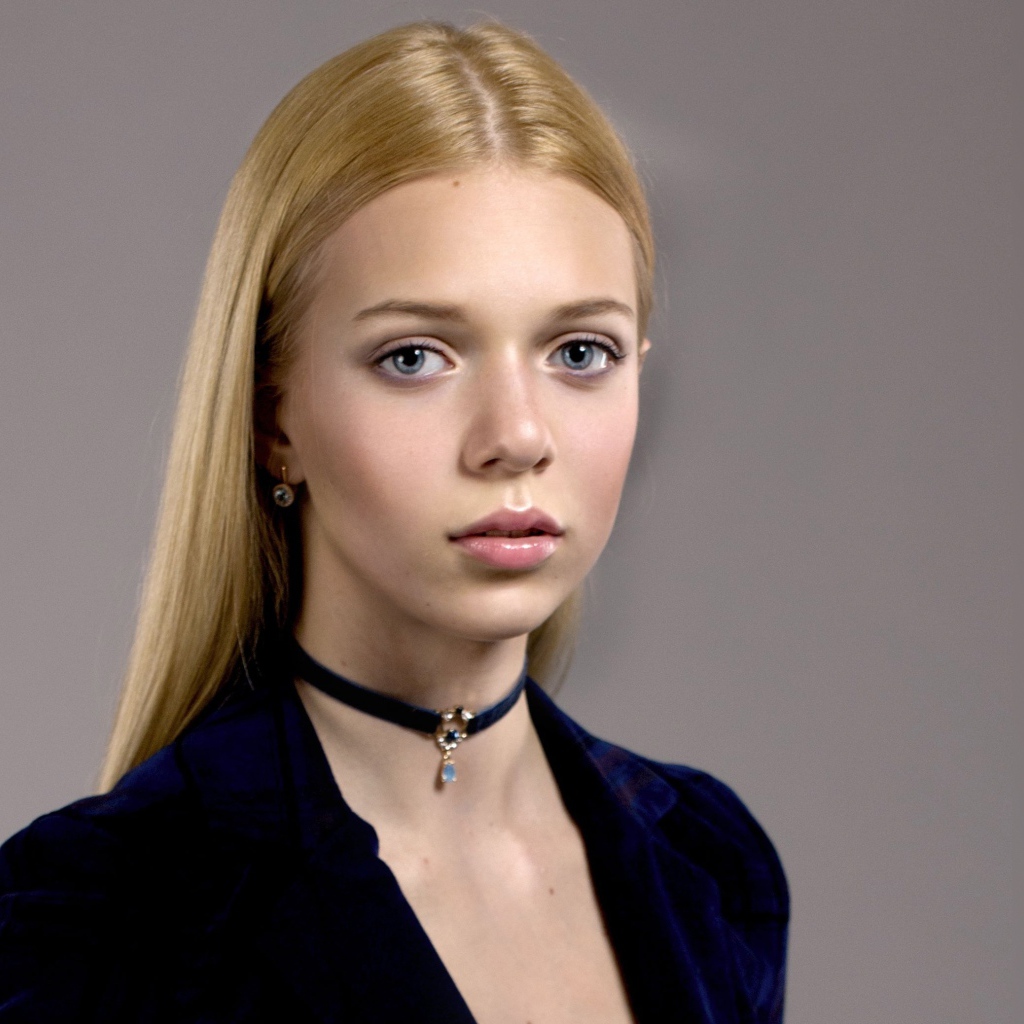 Нежная голубоглазая девушка с украшением на шее 