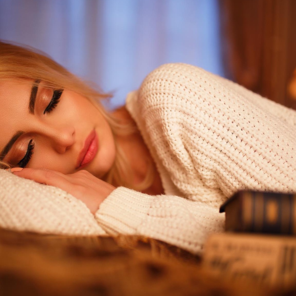 Нежная спящая блондинка в белом свитере 