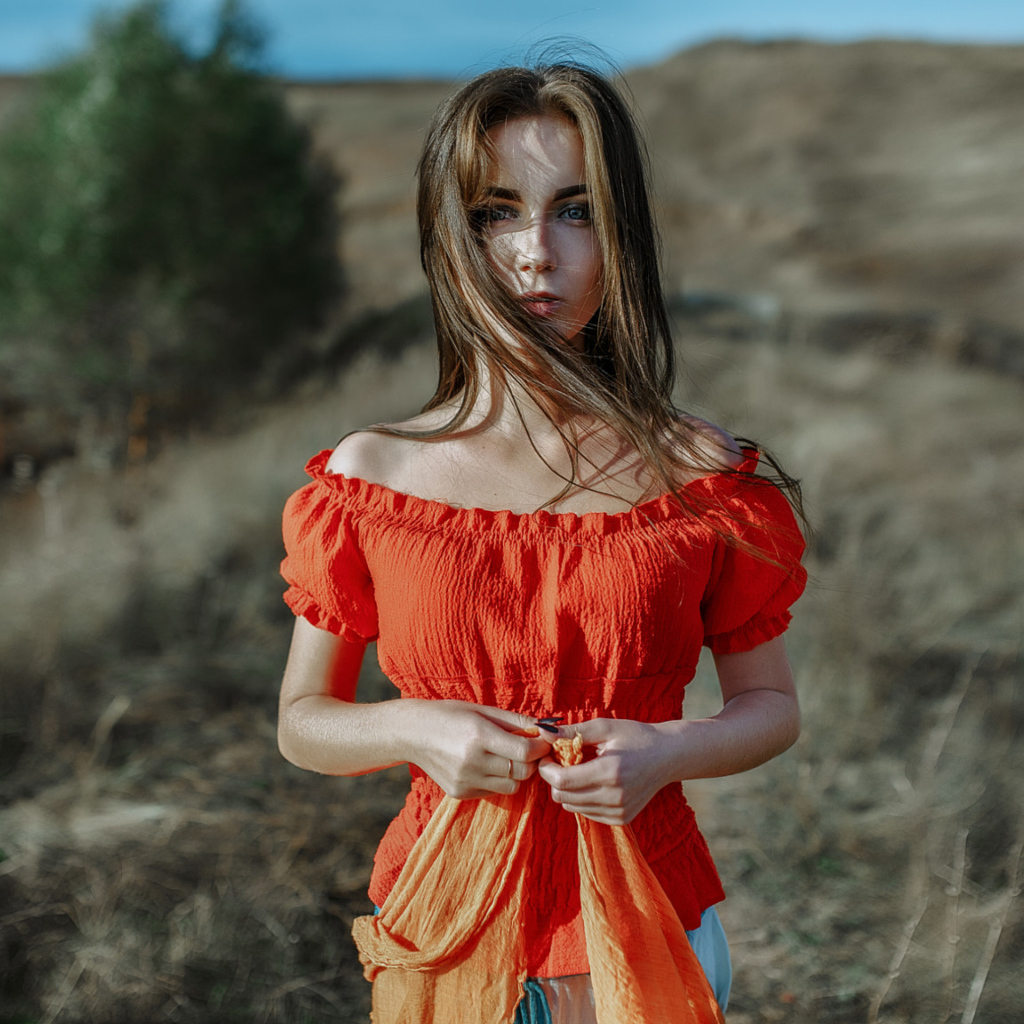 Ветер развивает волосы красивой девушке шатенке 