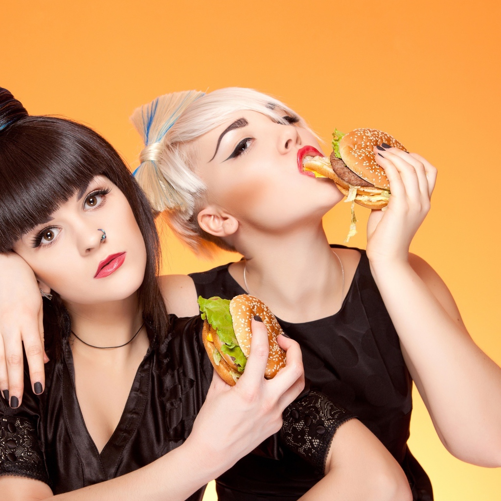 Две девушки с ярким макияжем с гамбургерами
