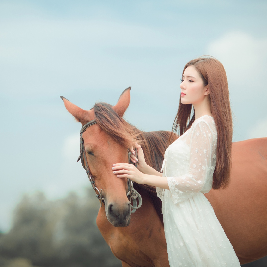 Молодая азиатка в белом платье с лошадью 