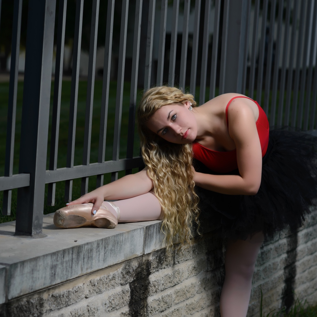 Молодая красивая девушка балерина делает растяжку