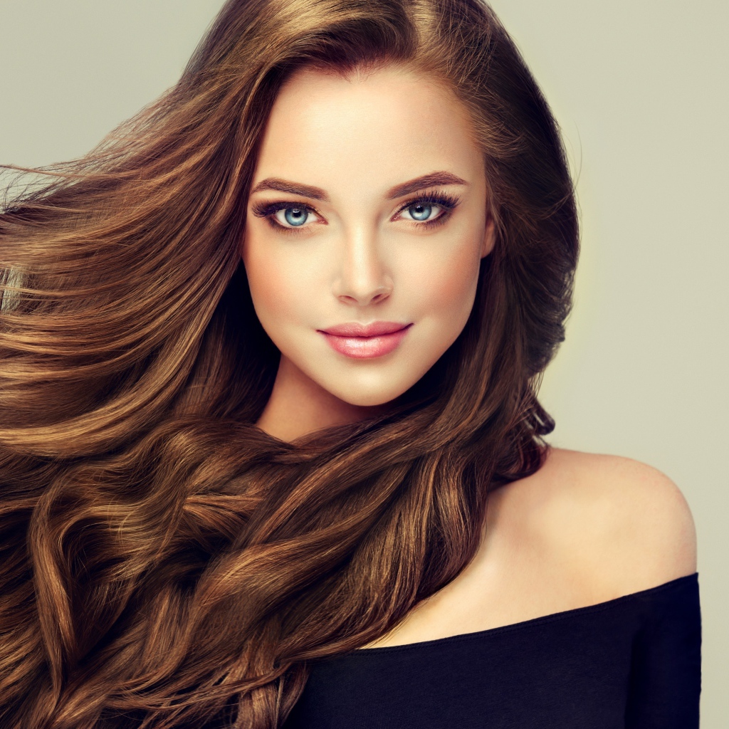 Молодая голубоглазая девушка с красивыми длинными волосами