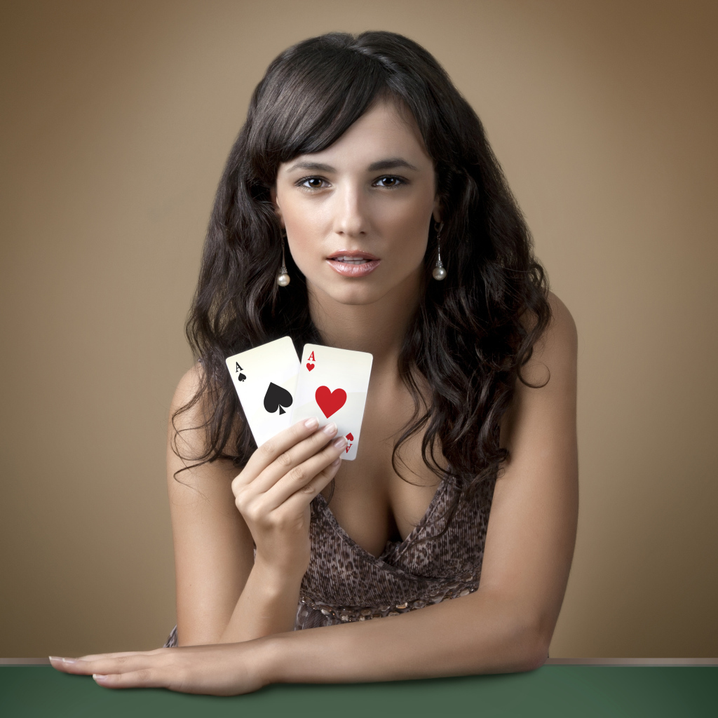 Молодая брюнетка с двумя карточными тузами в руке